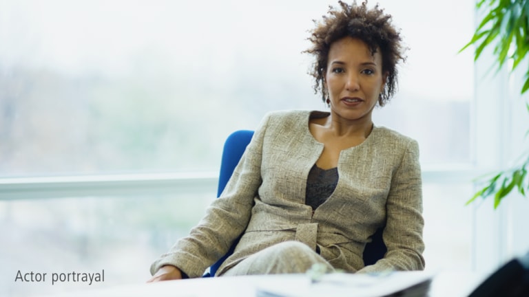 Black female in beige suit representing hypothetical Serostim® patient, Natalie, actor portrayal