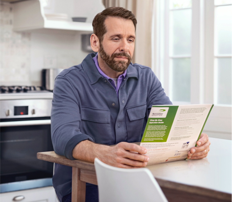 Middle-aged white male in blue jacket reviewing Serostim® Step by Step Injection Guide, not actual patient